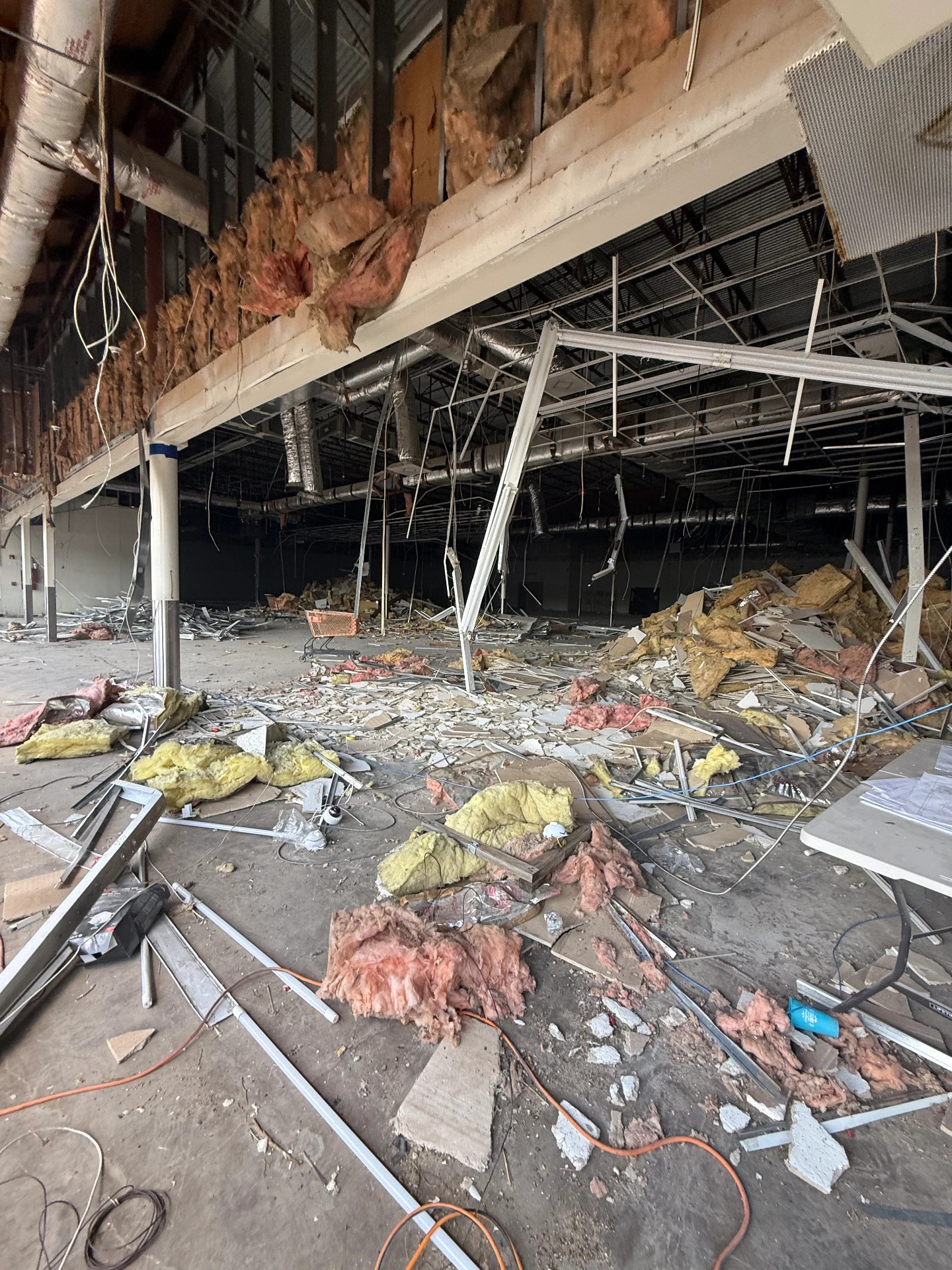 Large-scale interior demolition with removed insulation and ceiling grid